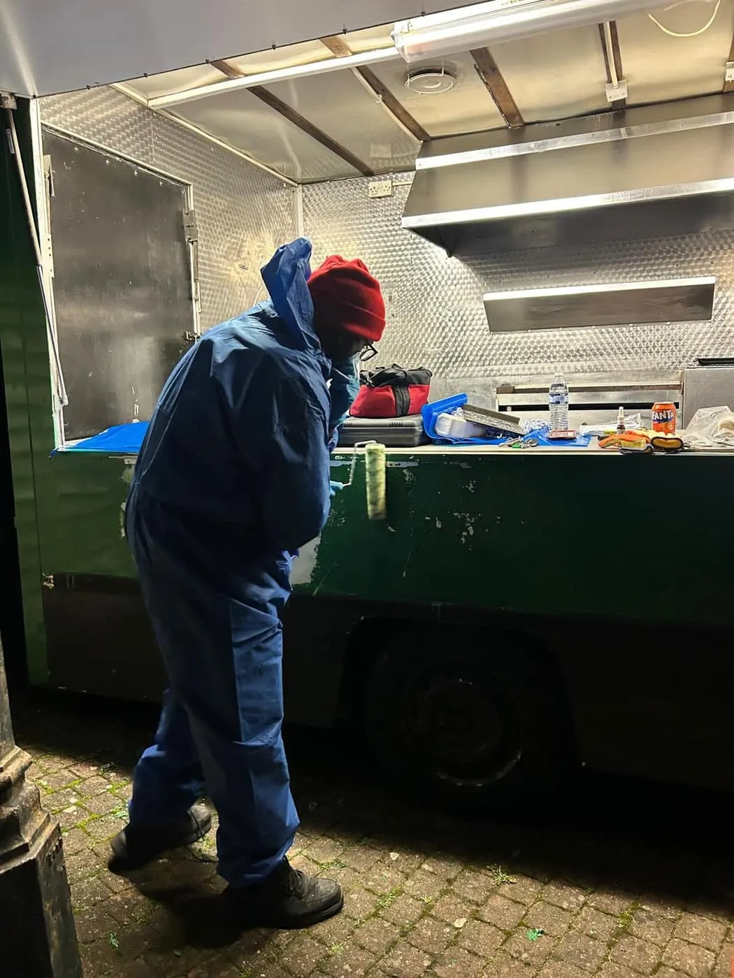 Mikhail in PPE deep-cleaning and stripping out the van
