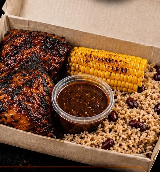 Jerk chicken with grilled corn and rice & peas in a takeaway box